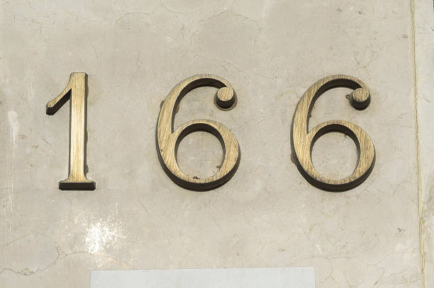istock Bronze house number one hundred and sixty-six on a marble wall. 1366441921