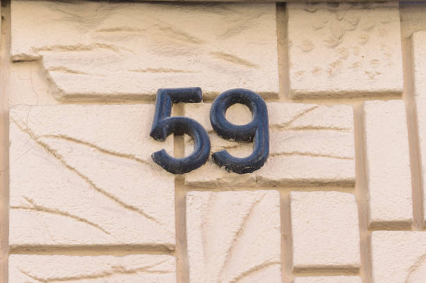 istock Enameled house number fifty-nine (59) on a wall. 1366441971