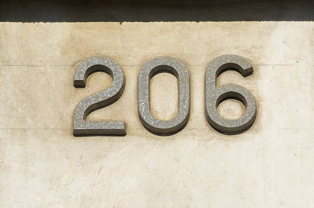 istock House number two hundred and six on a concrete wall. 1366442480
