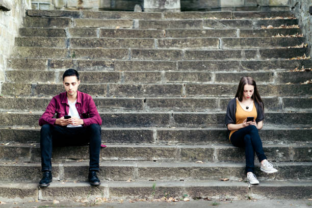 istock Relationship problems. Unhappy young couple. Man and woman sitting  and texting using smartphones. 1366442882