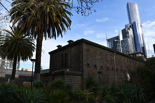 Melbourne, Australia - September 2, 2019: Skyscrapers seen behind an outside wall of the Old Melbourne Gaol.