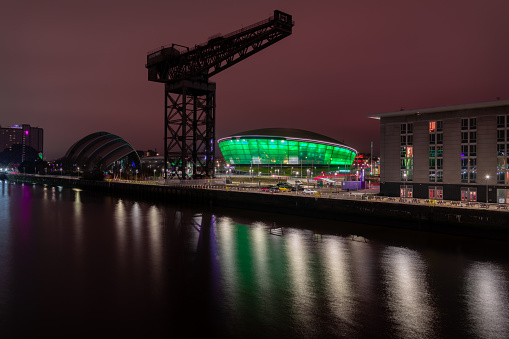 The Finnieston Crane on the river Clyde with the Hydro  multi-purpose indoor arena illuminated in green in the background.