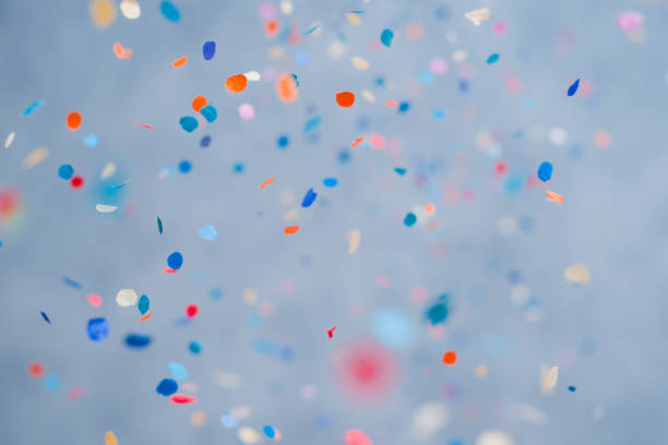 красочные конфетти, падающие на праздник на синем фоне - годовщина фотографии стоковые фото и изображения