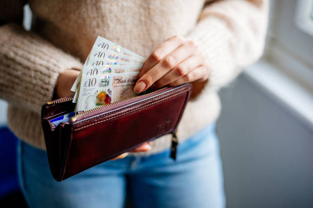 mujer sosteniendo libra esterlina - pound symbol ten pound note british currency paper currency fotografías e imágenes de stock