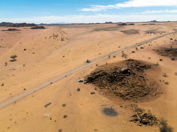 istock Aerial view dirt road through arid landscape 1366447584