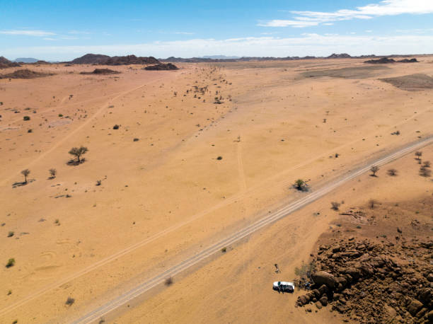 istock Parked vehicle with dirt road through arid landscape 1366447614