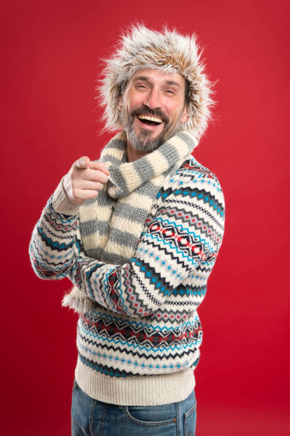 laughing at something funny. mature fashion model in cold weather style. winter male wardrobe. bearded man accessorizing sweater with hat and scarf. a winter ensemble protects him from cold - fashion men fashion model male imagens e fotografias de stock