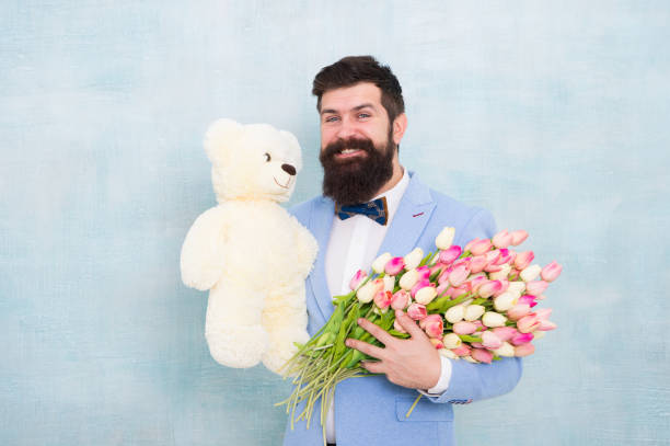 Man bearded gentleman suit bow tie hold teddy bear and bouquet. Happy and in love. Gentleman making romantic surprise for her. Gentleman romantic gift. Birthday greetings. Happy birthday my love Man bearded gentleman suit bow tie hold teddy bear and bouquet. Happy and in love. Gentleman making romantic surprise for her. Gentleman romantic gift. Birthday greetings. Happy birthday my love. man with teddy bear stock pictures, royalty-free photos & images