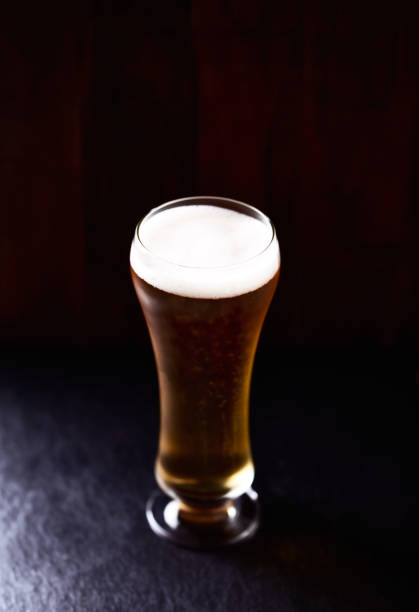 istock Glass of beer on stone background. Copy space. 1366452306