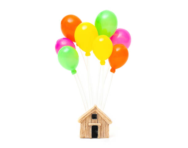 istock Toy house model with multicolored balloons on white 1366453898