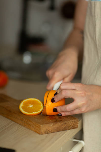 istock a woman slices an orange 1366455231