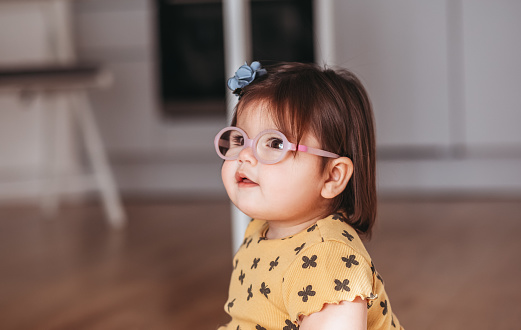 baby girl with poor eyesight.child with glasses.Cute  girl wearing glasses playing  happily
