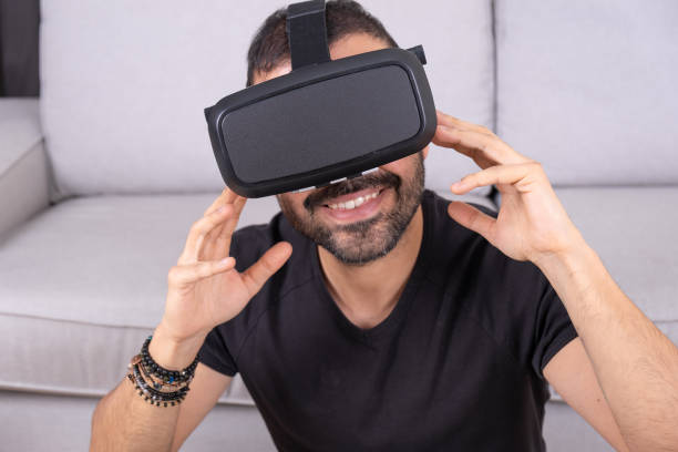 istock Young man in VR glasses headset at home interacting with virtual reality, gesturing. close up. future technology, education video gaming 1366456649