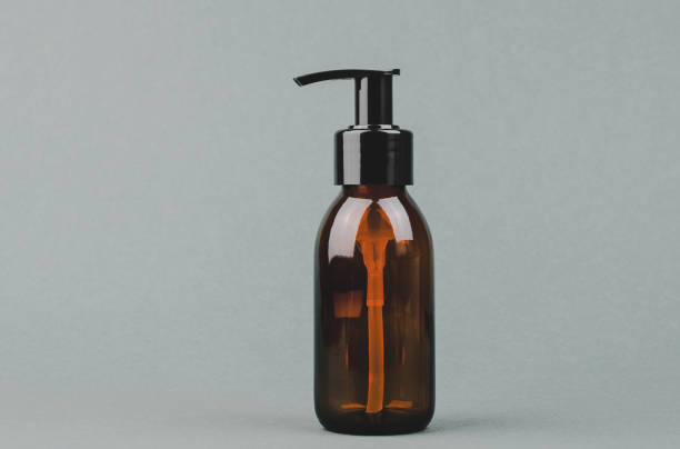 Cosmetic bottle with a dispenser on a gray background with space for text.