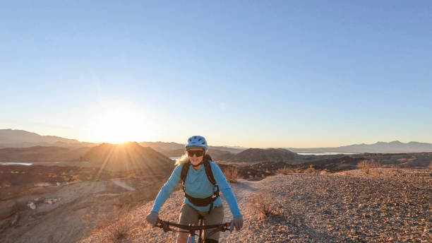 istock Female mountain biker follows desert pathway 1366456934