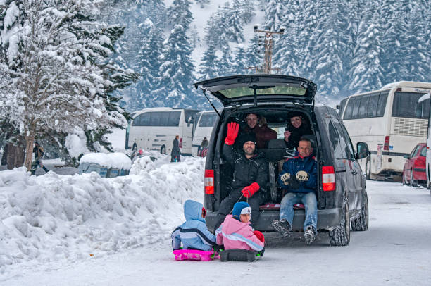 アバント湖自然公園で子供たちを楽しませるために車でそりを引っ張る家族。 - motor vehicle outdoors crowd landscape ストックフォトと画像