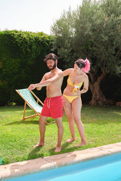 istock Young caucasian woman applying sunscreen on a man's back. 1366458672