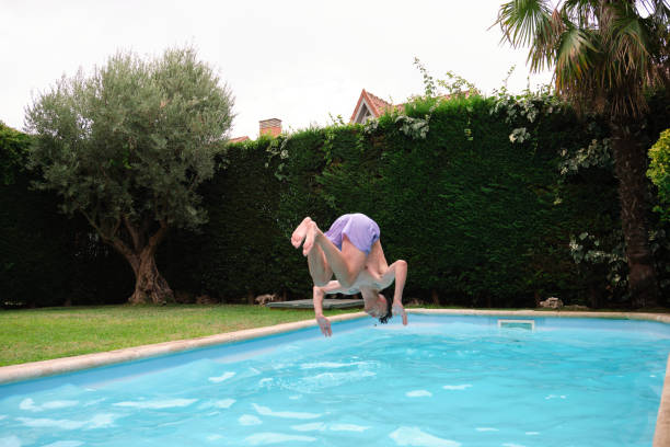 istock Young caucasian man jumping into the swimming pool. 1366458701