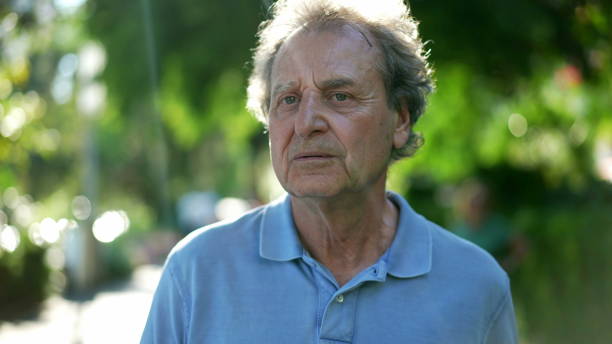 istock One happy older man walking outside during sunny day, pensive contemplative senior 1366458708