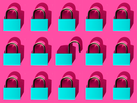 Some blue padlocks arranged in different lines forming a mosaic on a pink background. security concept