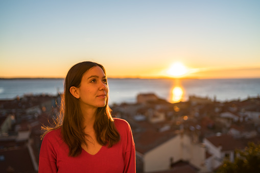 She relaxes over medieval village, as the sun rises over the Mediterranean Sea