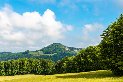 View over the mountain ranges and their grasslands and forests in the morning light in the northern Jura Mountains of the canton of Solothurn near the Passwang mountain pass