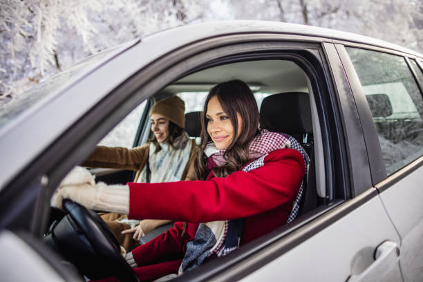 jeunes femmes en road trip hivernal - winter driving photos et images de collection