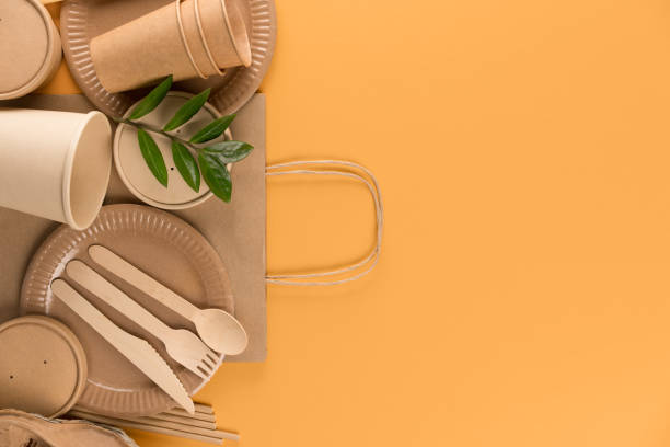 istock Eco-friendly tableware set - kraft paper food packaging, paper containers and cups, drinking straws on orange background with copy space. Street food paper packaging concept 1366462915