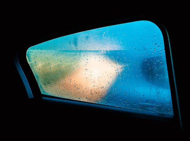 View through a fogged and rain-soaked window with backlight stock photo