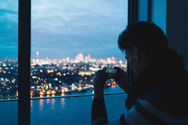 istock Young man looks out window, to city lights 1366463165