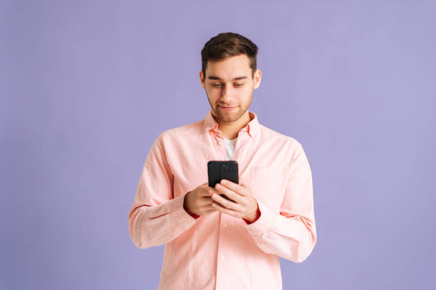 istock Portrait of handsome young man typing message using mobile phone to communicate online, chatting in social network, scrolling media pictures . 1366463320