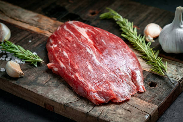 raw flank beef steak and ingredients for cooking on a wooden board, close up - flank steak imagens e fotografias de stock