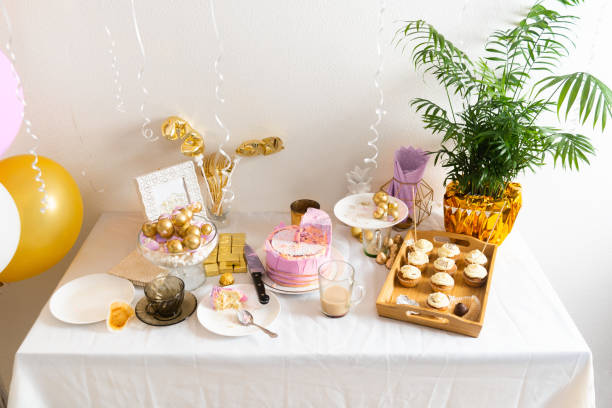 istock Table with leftovers after birthday with coffee, cake, cupcakes 1366466319