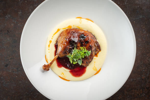 istock Cooked Duck legs with mashed potatoes with lingonberry sauce and herbs, top view 1366466507