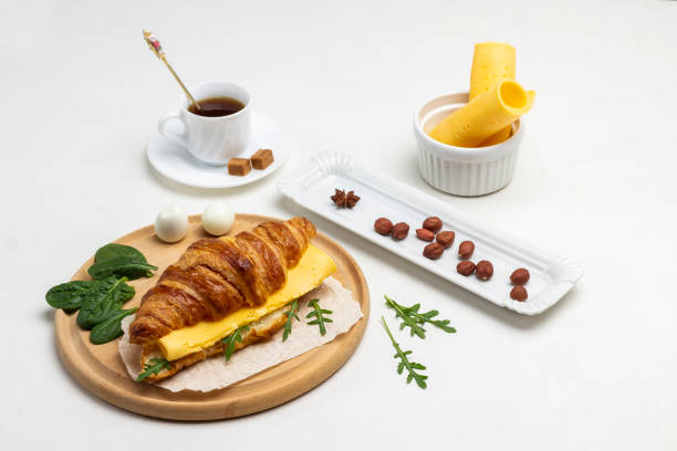 Croissant with cheese and greens, two eggs.