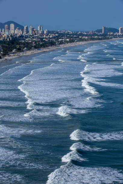 istock Waves hitting the beach with city in the background 1366468243