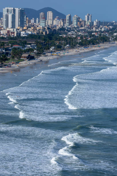 istock Waves hitting the beach with city in the background 1366468261