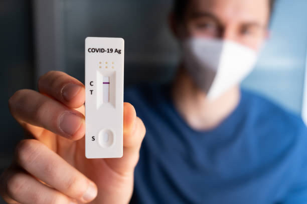 istock Young man with mask holding a negative self home test. Corona virus - Covid-19 rapid test. Young caucasian male. Negative result. 1366469374