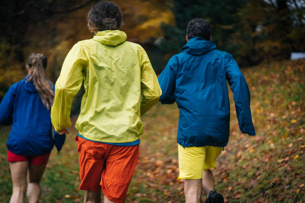 istock Trail runners run through forest on rainy day 1366472332