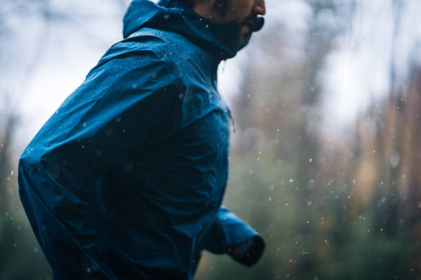 les coureurs de trail courent à travers la forêt les jours de pluie - cross coat photos et images de collection