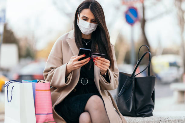 istock Young woman shopping with smartphone outside 1366473737