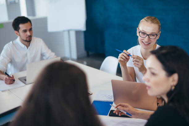 istock Associates discussing at work in the office. 1366475459