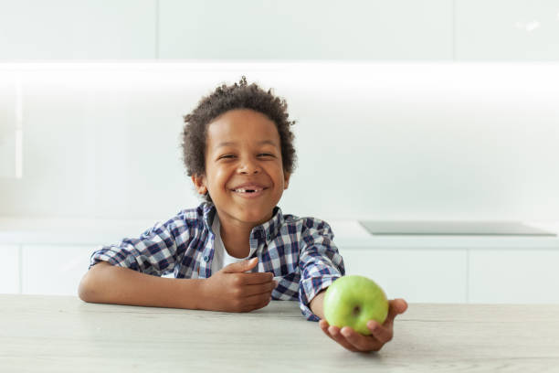 緑のリンゴを持つ小さな子供の男の子 - child eating apple fruit ストックフォトと画像