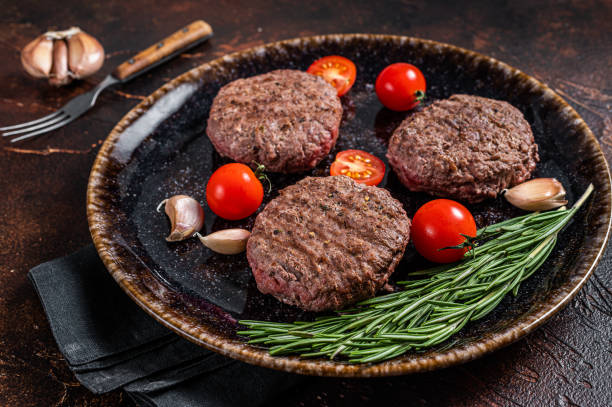 istock Hamburger grilled meat cutlets patties with herbs. Dark background. Top view 1366477412