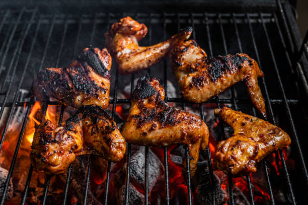 istock Chicken wings on barbecue, outdoor BBQ grill with fire. Top view 1366478362