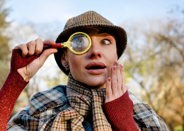 femme excentrique déguisée en sherlock holmes avec un appareil photo vintage à la recherche de preuves dans un parc d’automne - detective spy women fashion photos et images de collection