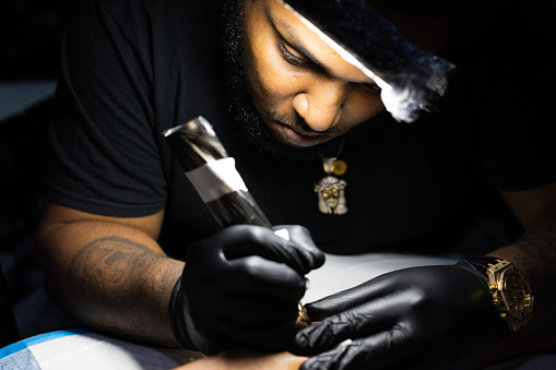 Portrait of tattoo artist concentrated on his work. Closeup. High quality photo