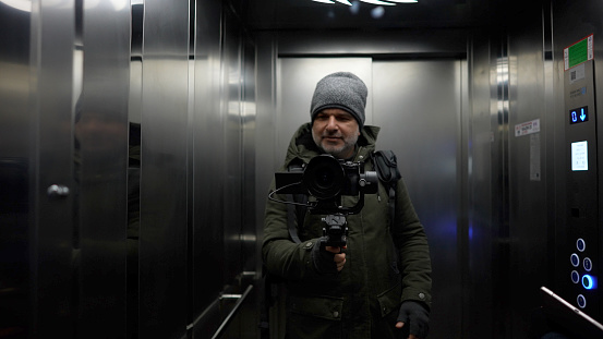 Vlogger men using gimbal camera in elevator,Mirror selfie portrait