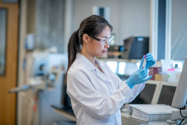 istock Female Laboratory Technician Checking a Blood Vial Sample 1366488401