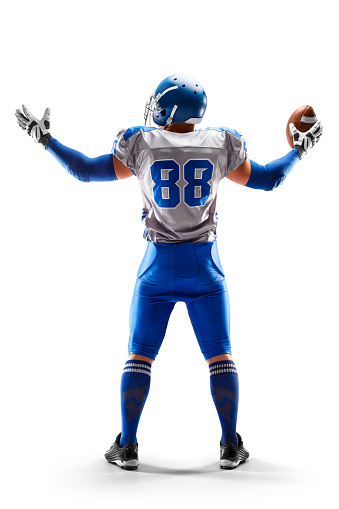 American Football player holding the ball in his hand. Joy in football. Sport emotions. Sport victory. Back view. Isolated on white background. Sport